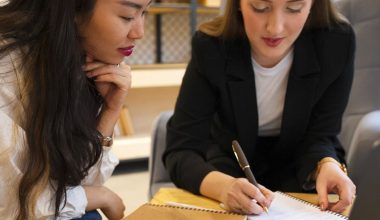 Deux femmes travaillant ensemble avec ordinateur et cahiers.