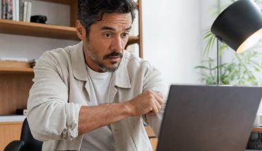 Professionnel du service client consultant les données d'une conversation gérée par un agent IA sur son écran de bureau